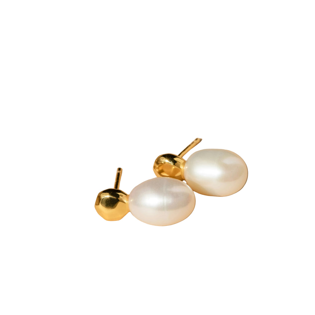 Ein Ohrringpaar von weißen Perlenohrringen in weißem Hintergrund